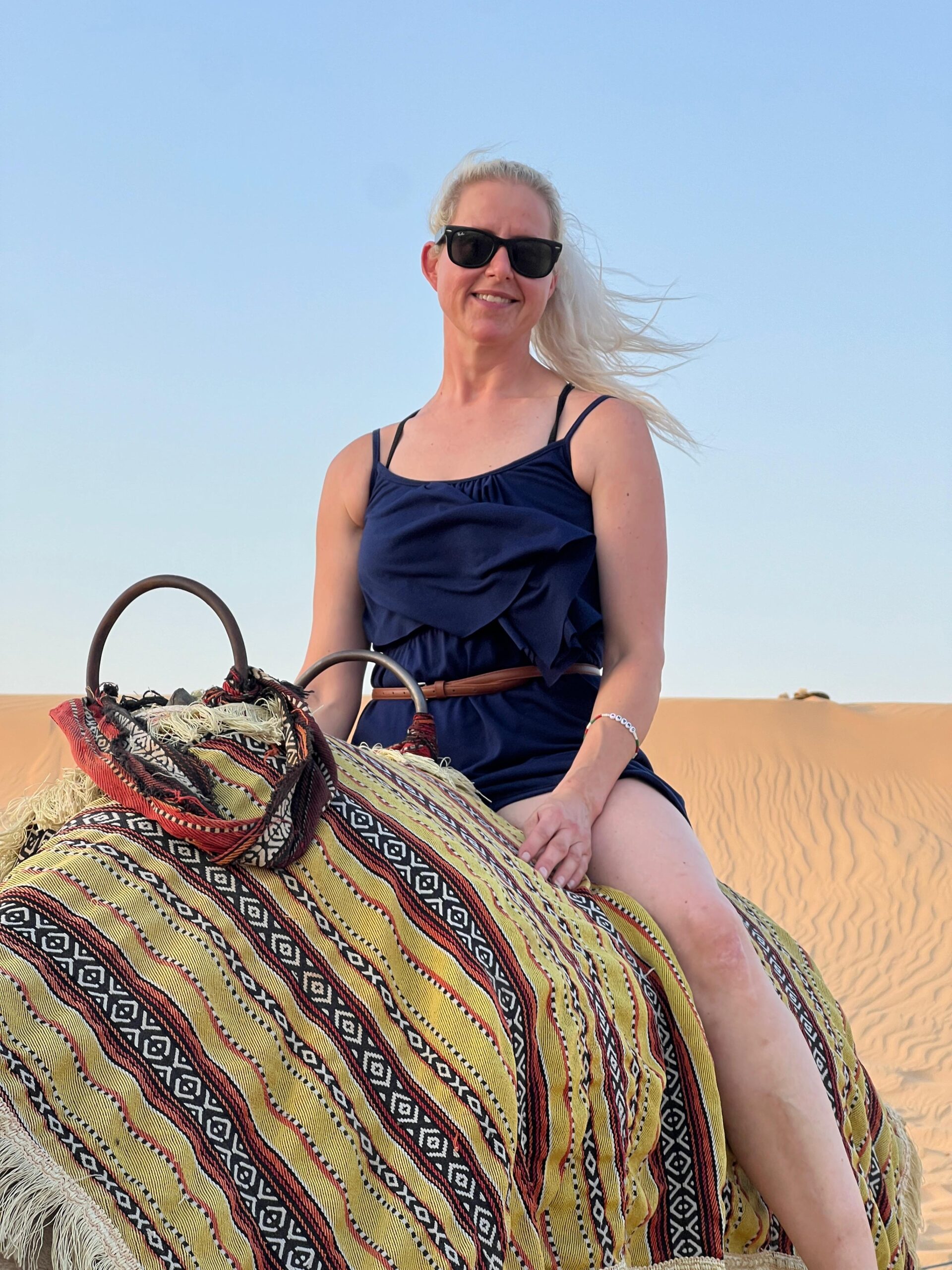 Tourists enjoying a traditional camel riding experience on an Abu Dhabi desert safari