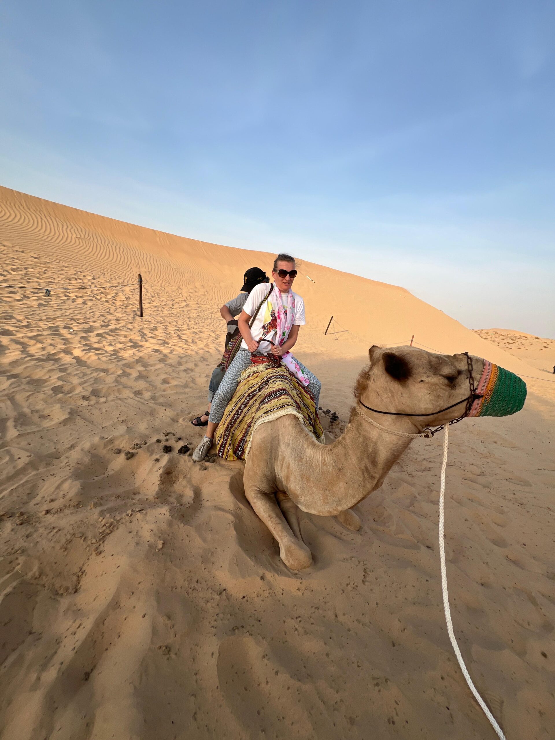 An adventurous rider on a quad bike kicking up sand on the red dunes of the desert