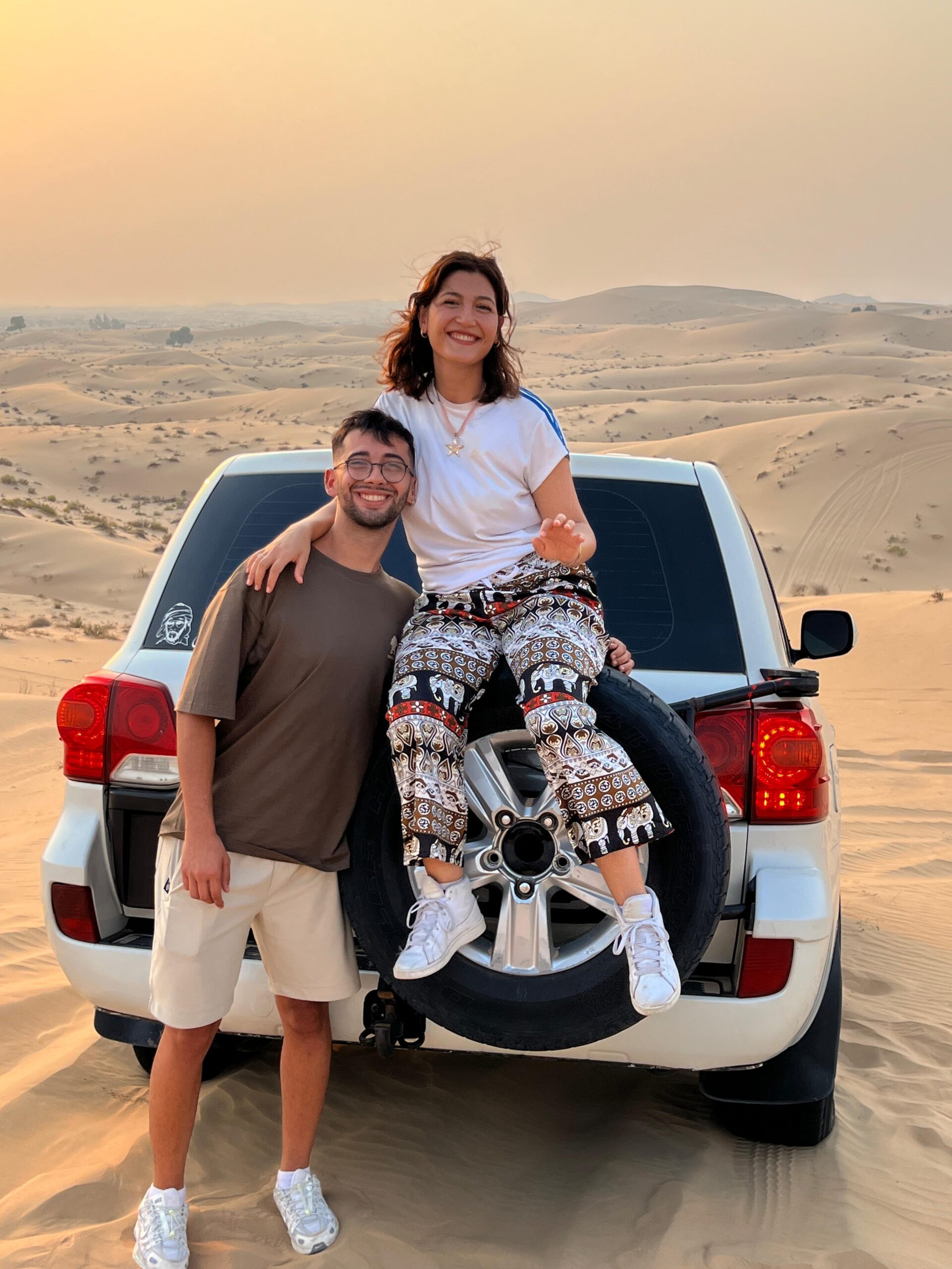 A powerful Toyota Land Cruiser climbing a steep red dune during an exciting desert safari