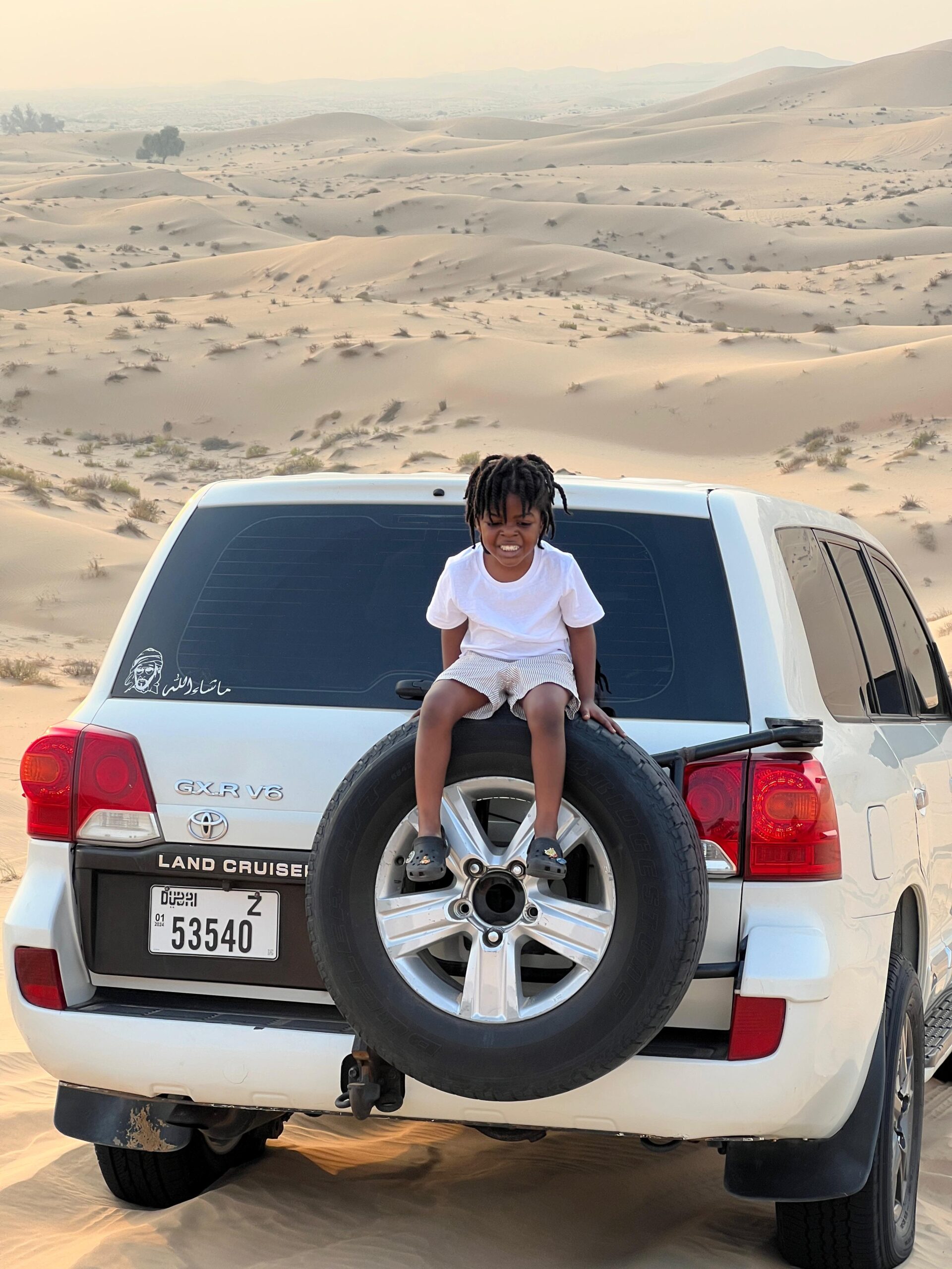 A guided quad biking tour group following an expert through the Abu Dhabi desert landscape
